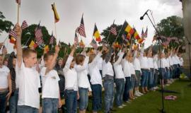 Local school children sing national anthems